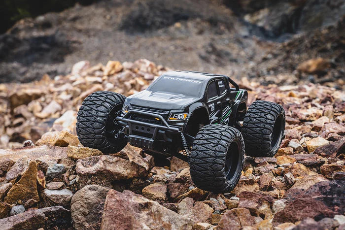 FMS 1/24 Chevrolet Colorado off-road monster truck on rocky terrain