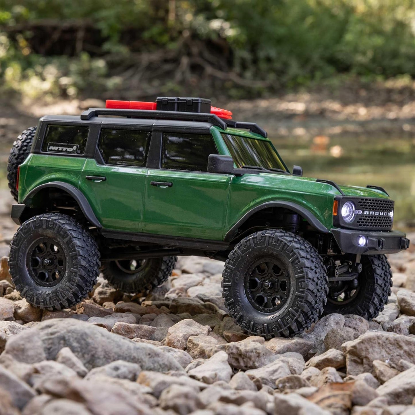 Remote controlled Axial SCX24 Ford Bronco in motion over rocky ground
