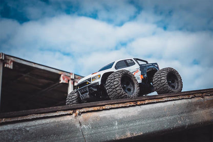 FMS 1/24 Chevrolet Colorado RC off-road truck with large wheels on a metal surface.