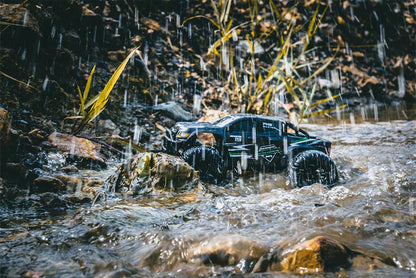 FMS 1/24 Chevrolet Colorado 4WD RC   rock crawler in a water stream with rocks and plants