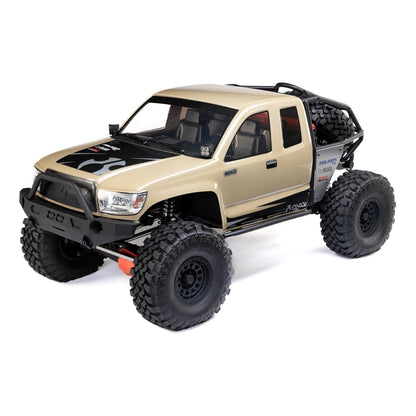 Axial SCX6 Trail Honcho 1/6 scale 4WD RTR rock crawler, front three-quarter view in beige body showing detailed cab, roll cage, massive tires, spare tire, and high-clearance chassis