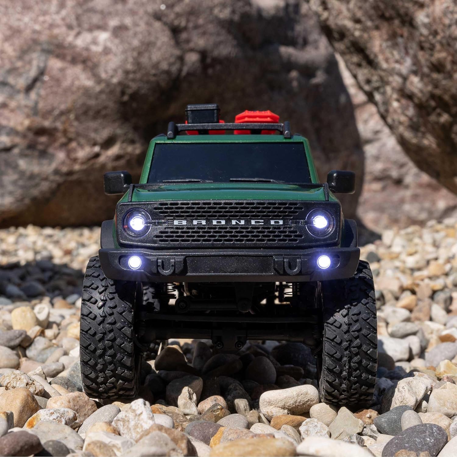 Front view of Axial SCX24 Ford Bronco rock crawler, highlighting grille and bumper on rocky terrain
