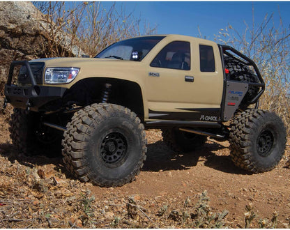 Beige off-road Axial SCX6 Trail Honcho 1/6 scale rock crawler with large tires on a rocky terrain