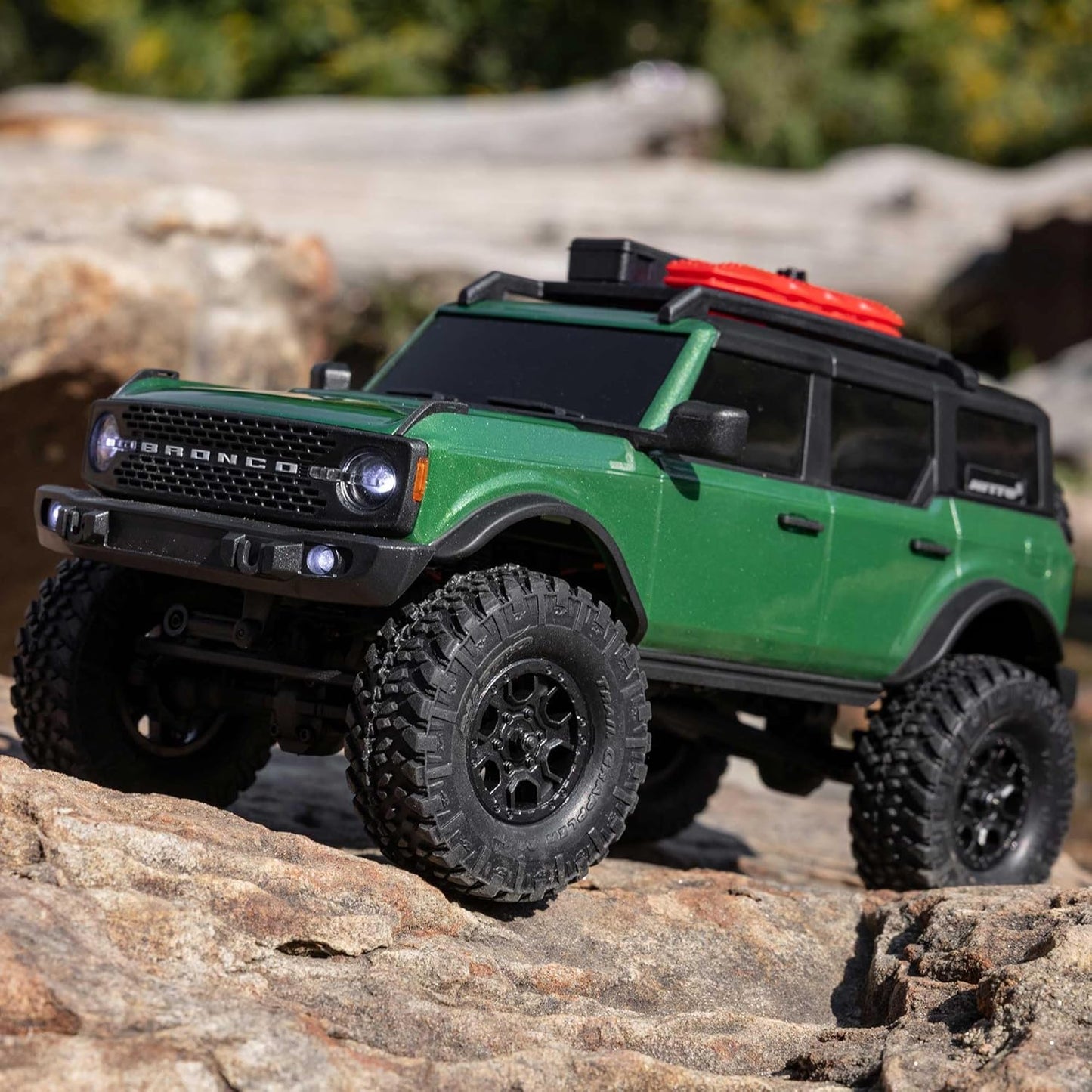 4WD scale RC rock crawler powering through uneven trail surface