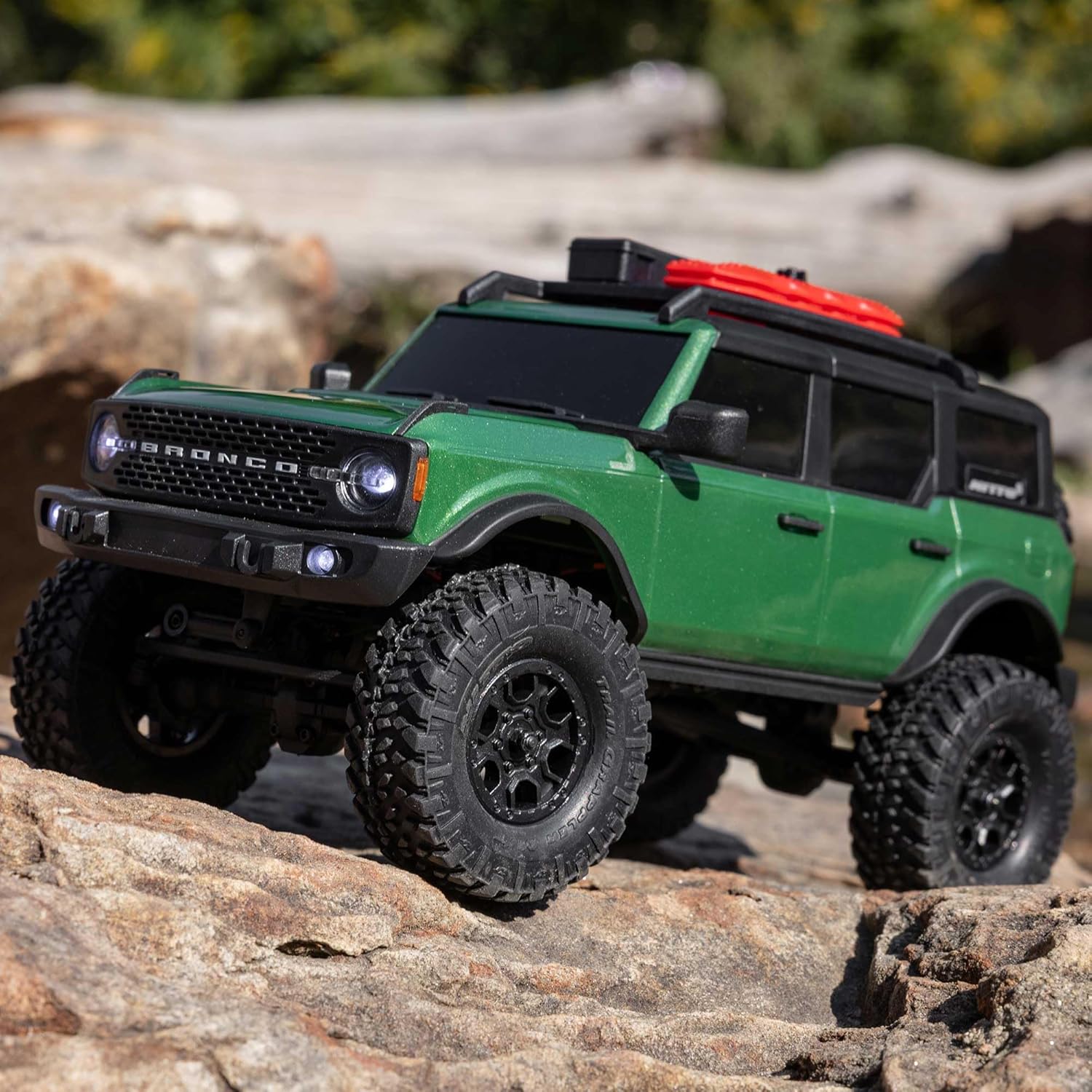 4WD scale RC rock crawler powering through uneven trail surface